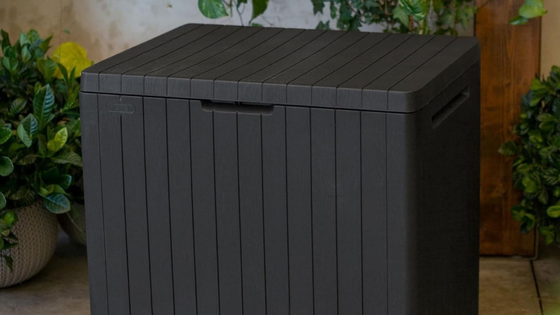 A Keter storage trunk outside on a patio.