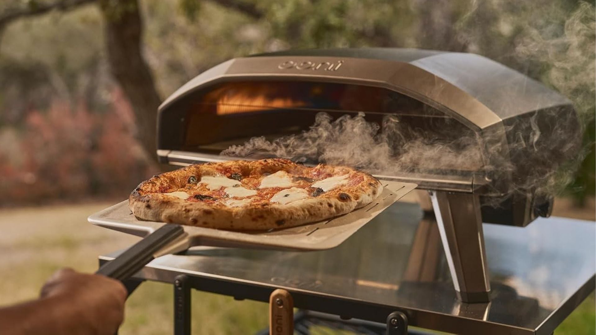 A person pulling a pizza oven out of the
Ooni Koda 2 Pro Propane Gas Pizza Oven.