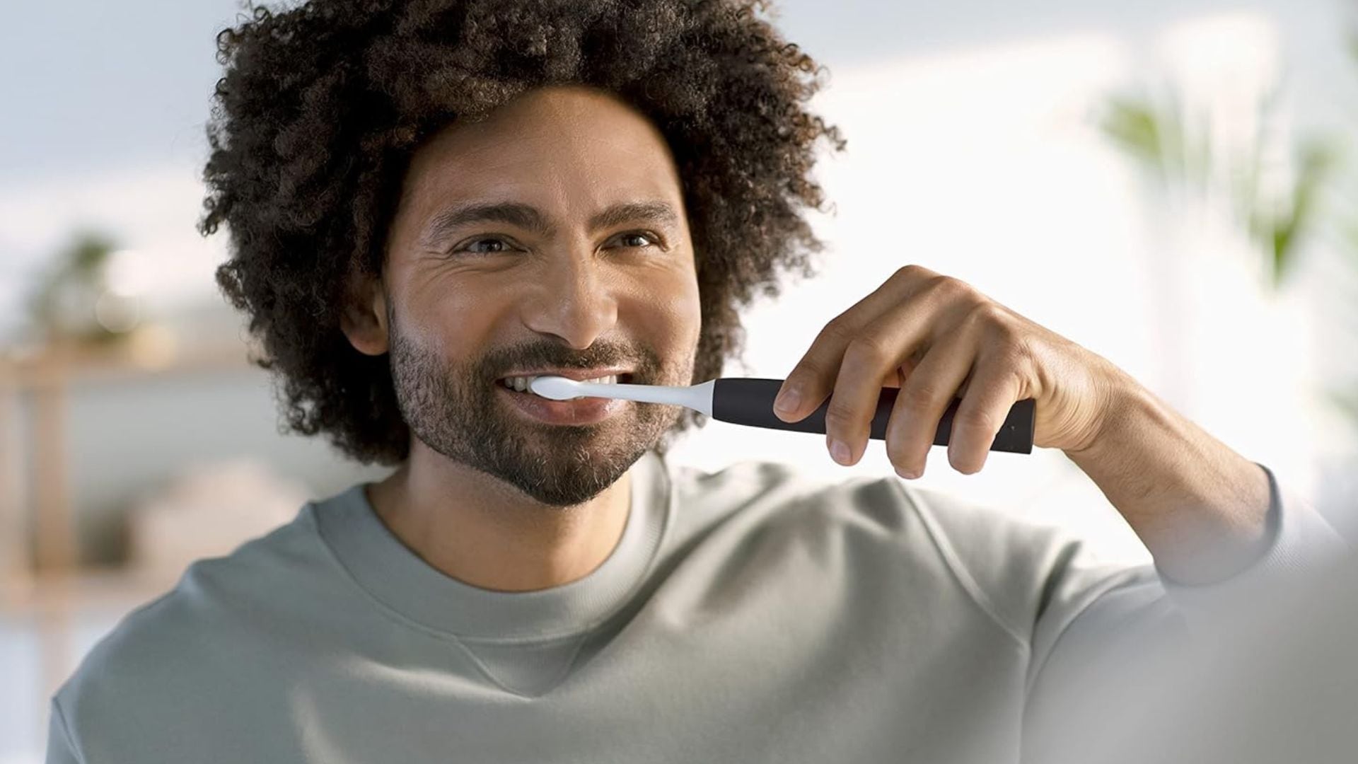 A person brushing their teeth with a Philips Sonicare toothbrush.