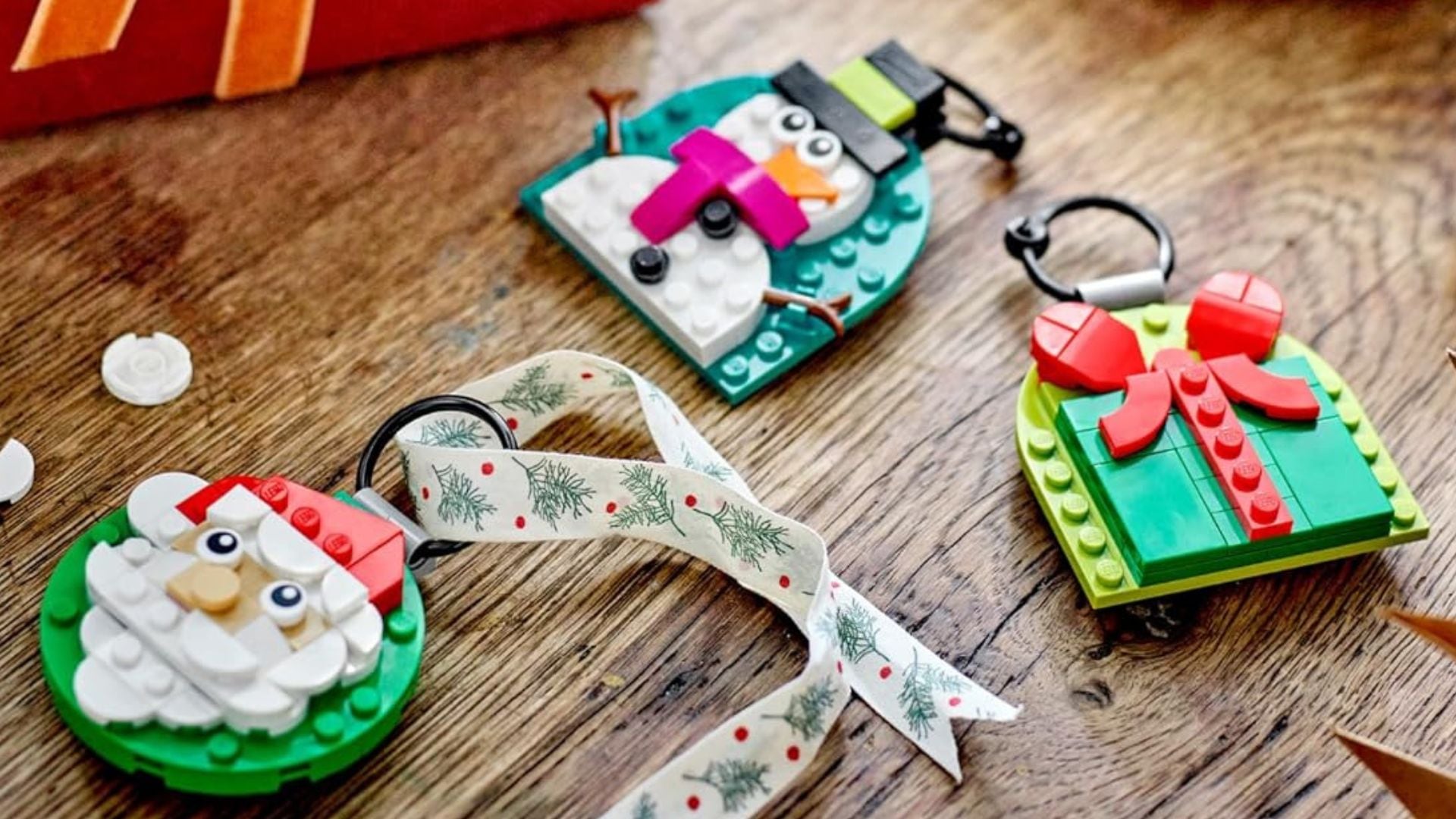 Three LEGO ornaments on a wooden floor.