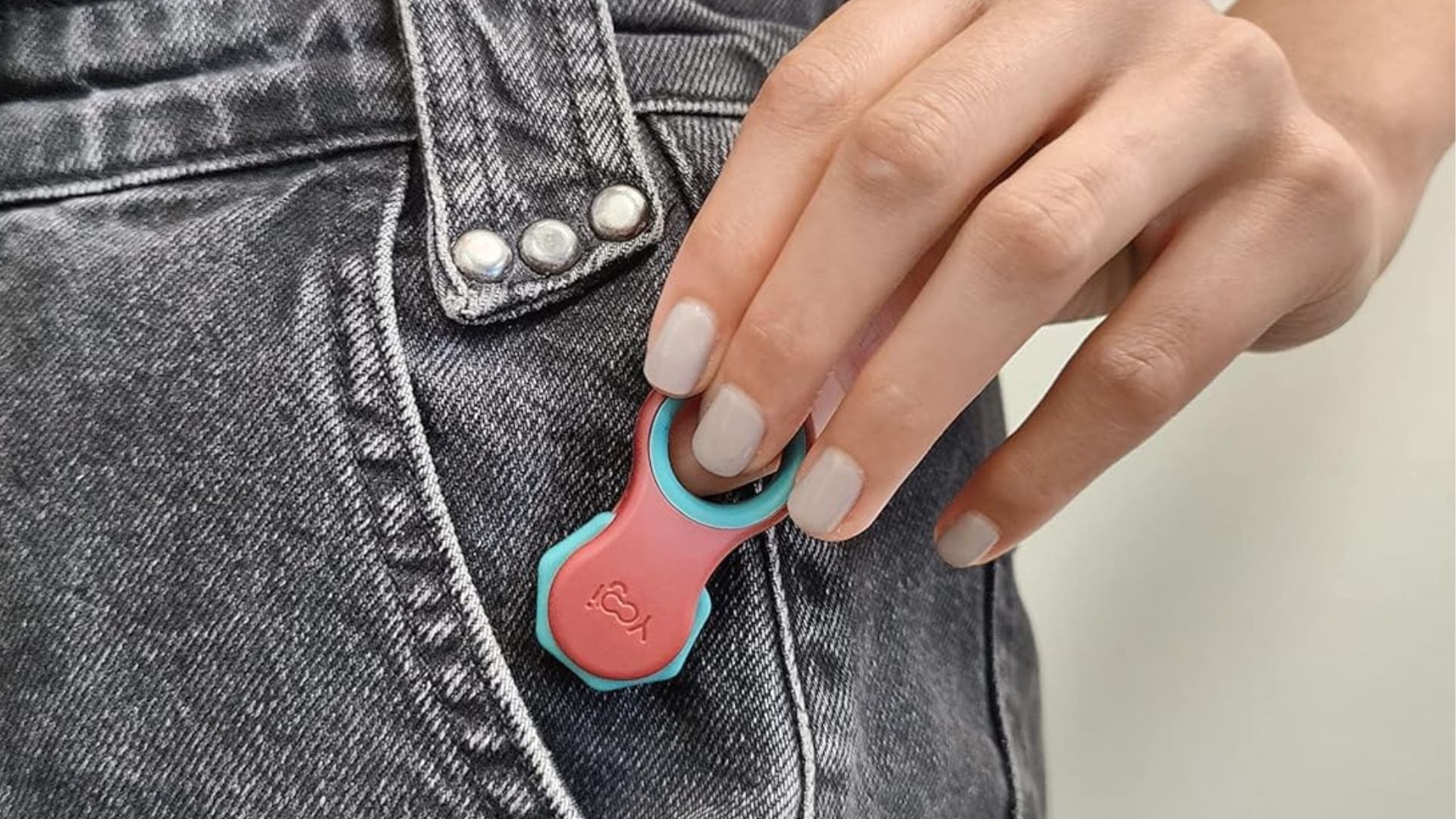 a person pulling a fidget toy out of their jeans pocket
