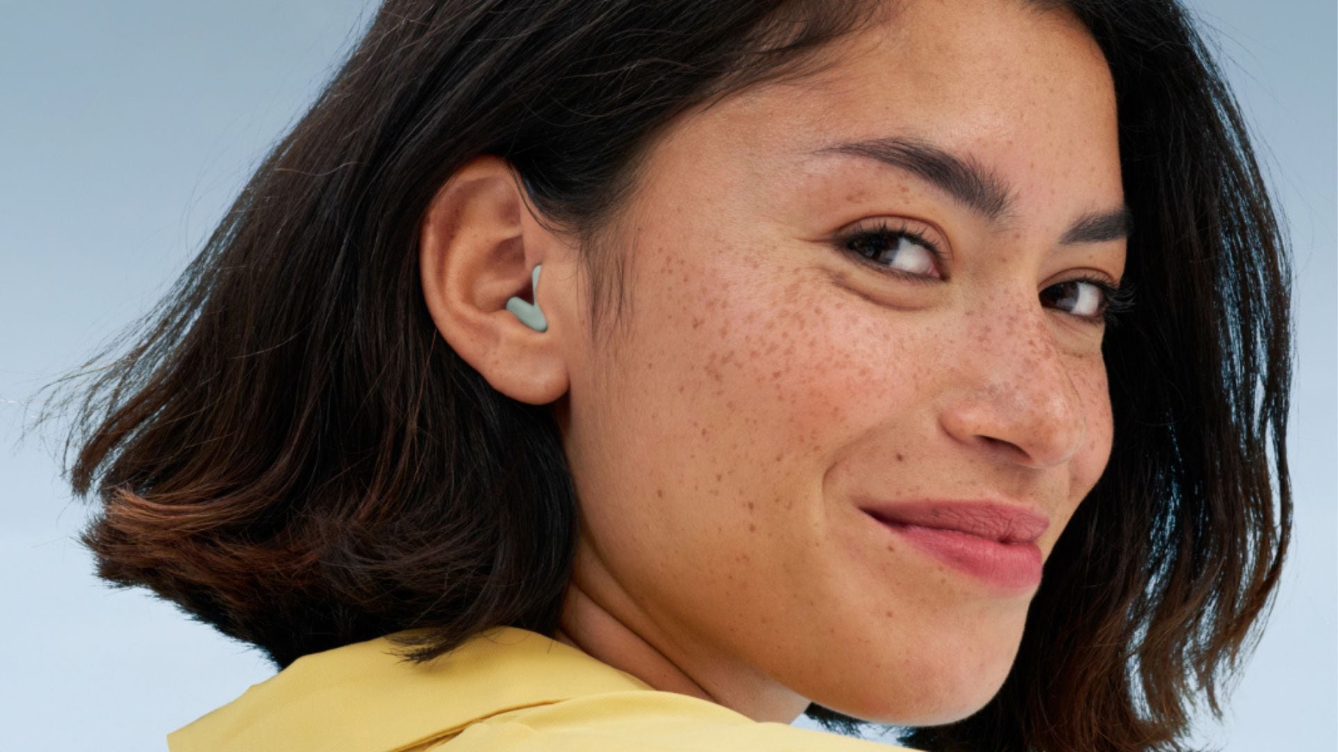 A person wearing Alpine Sleep earplugs.