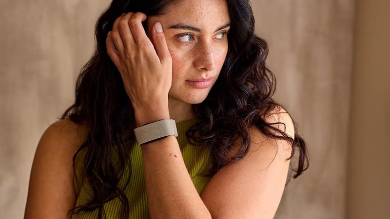 A person in a tank top wearing a Garmin CIRQA band.