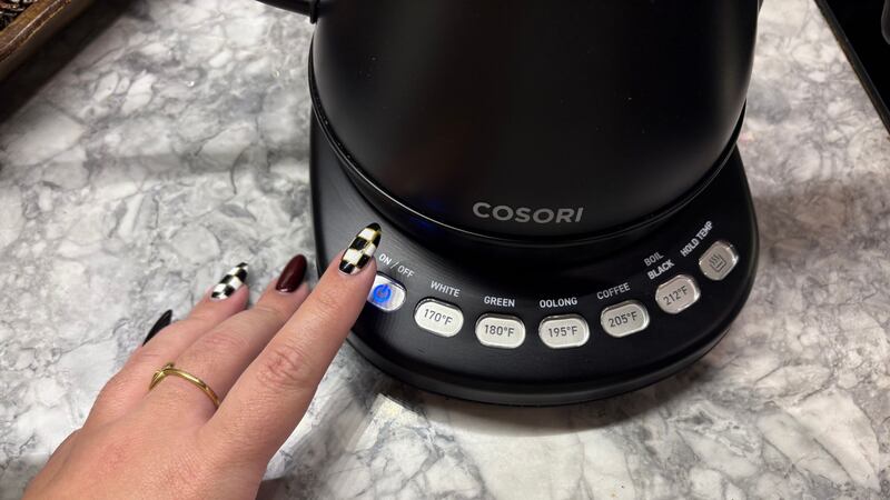 Bianca pressing the power button on the kettle