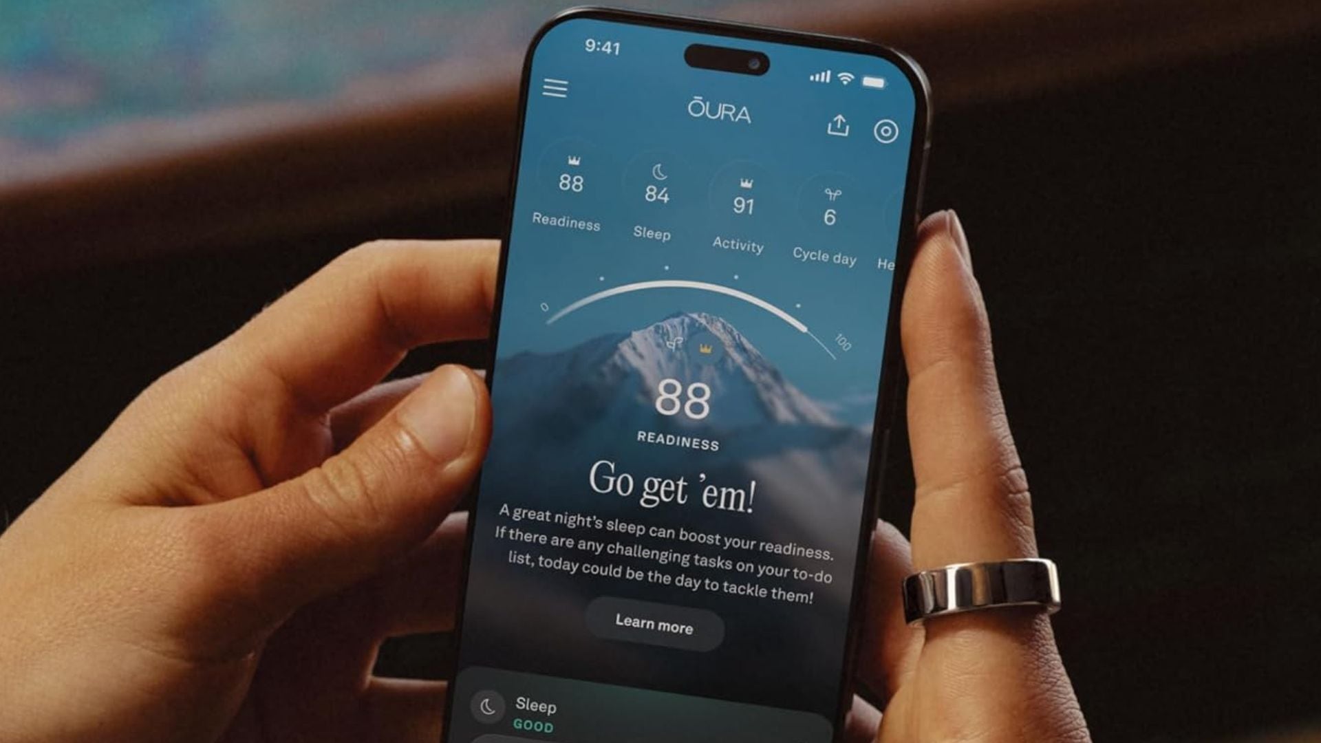 a person wearing an Oura ring with the companion app open on their phone