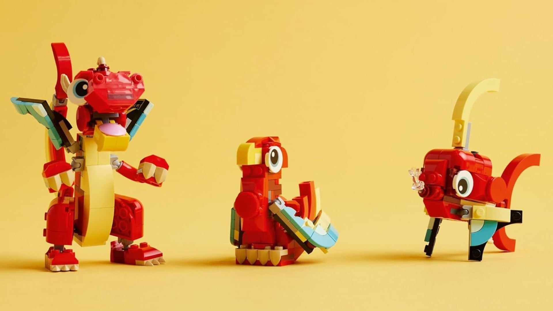 the red dragon, parrot, and fish Lego builds with a bright plain background