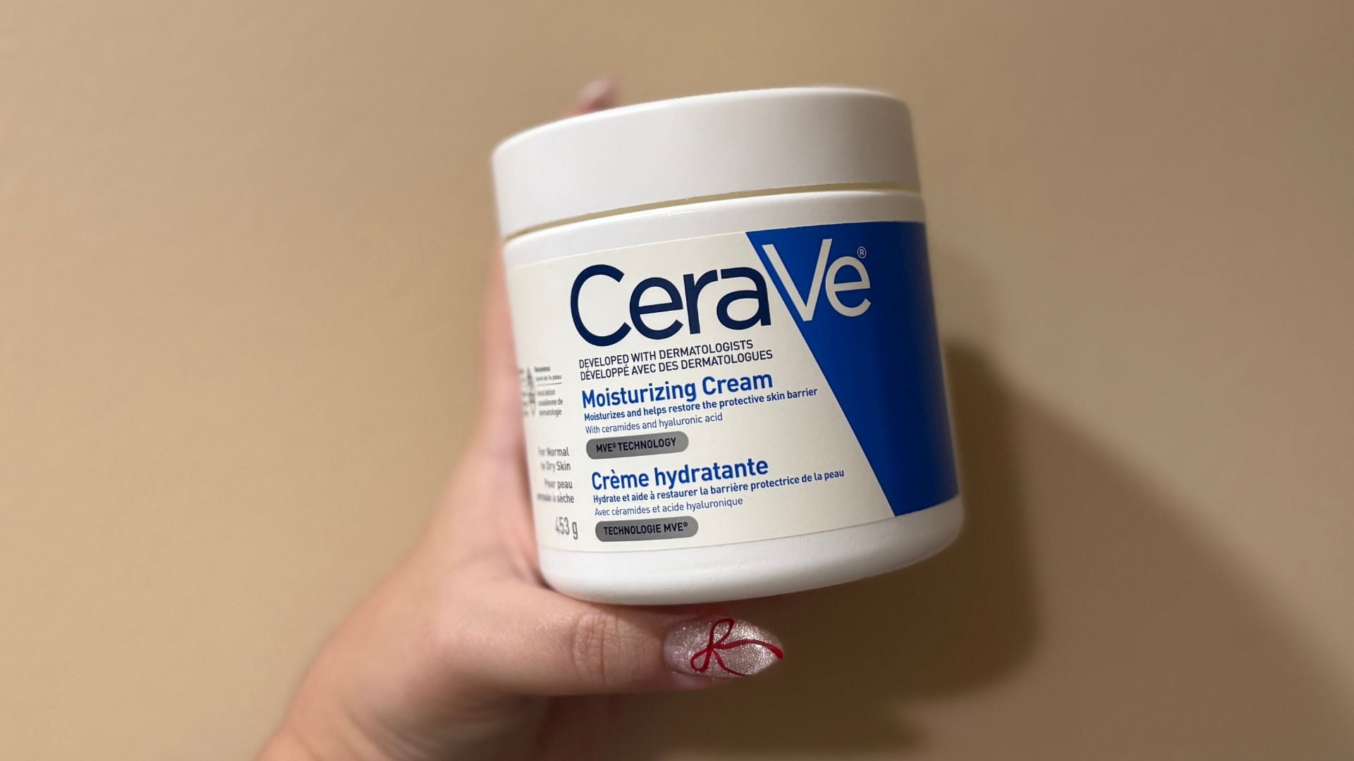 Bianca holding up the tub of moisturizer