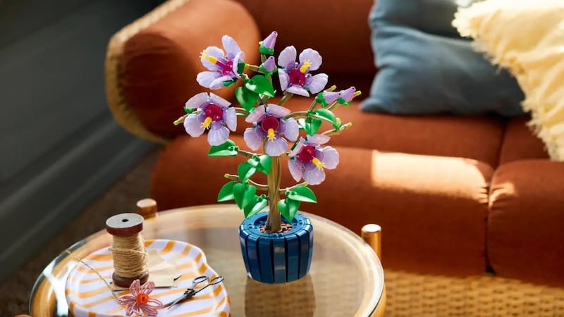 A LEGO Botanicals Hibiscus Flower Building Set is completed on a coffee table.