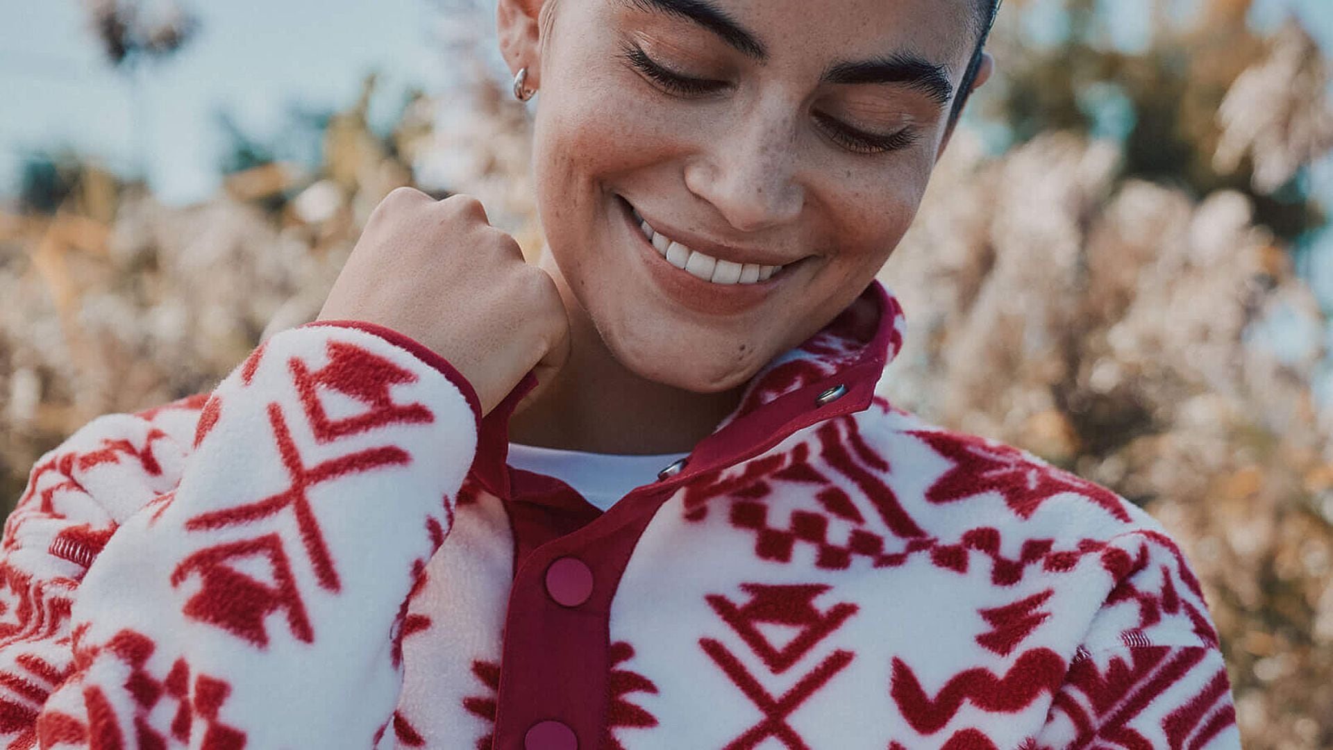 A person wearing a polar fleece from Simons and tugging at the collar.