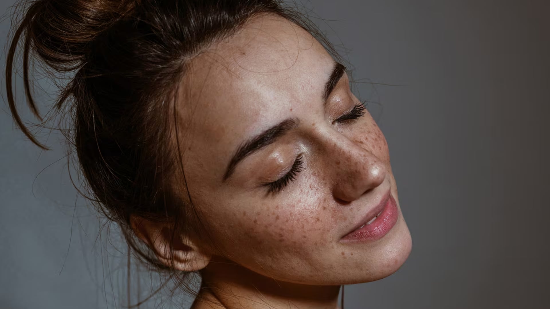 Model with freckles posing with closed eyes