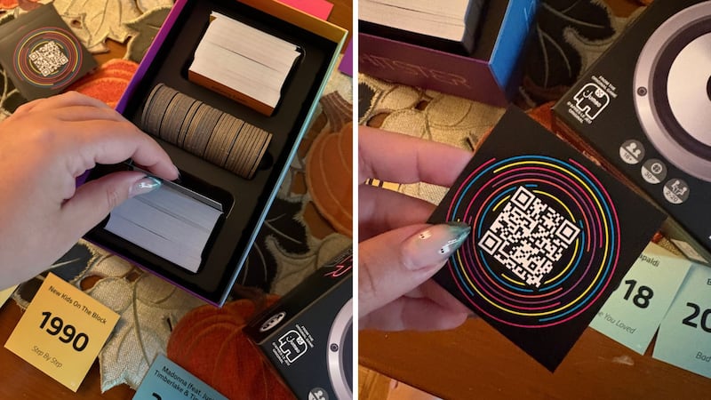 Bianca pulling a new song card out of the game box, and revealing the QR code to play the song preview on the card