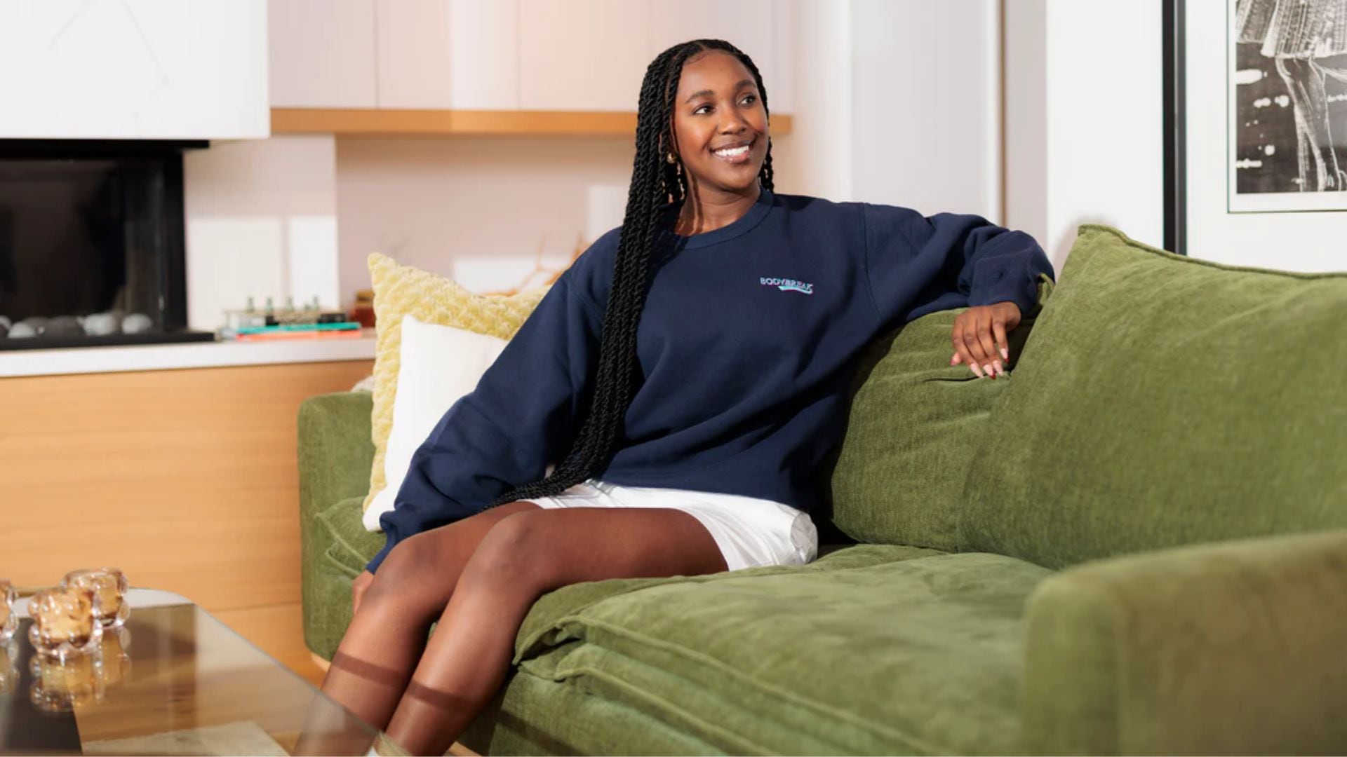 a model wearing a sweater sitting on a couch