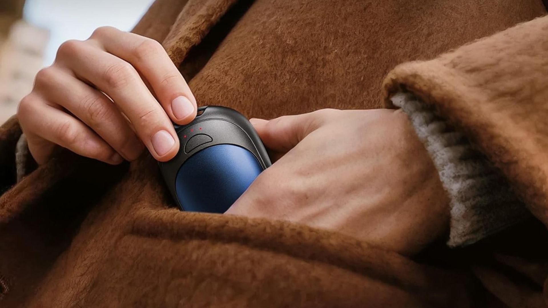 A person putting a hand warmer in their coat pocket.