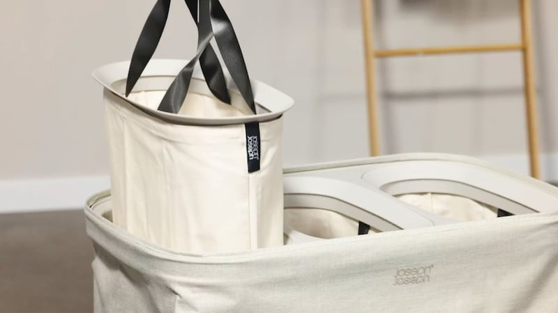 A person pulling a bag out of the laundry hamper.