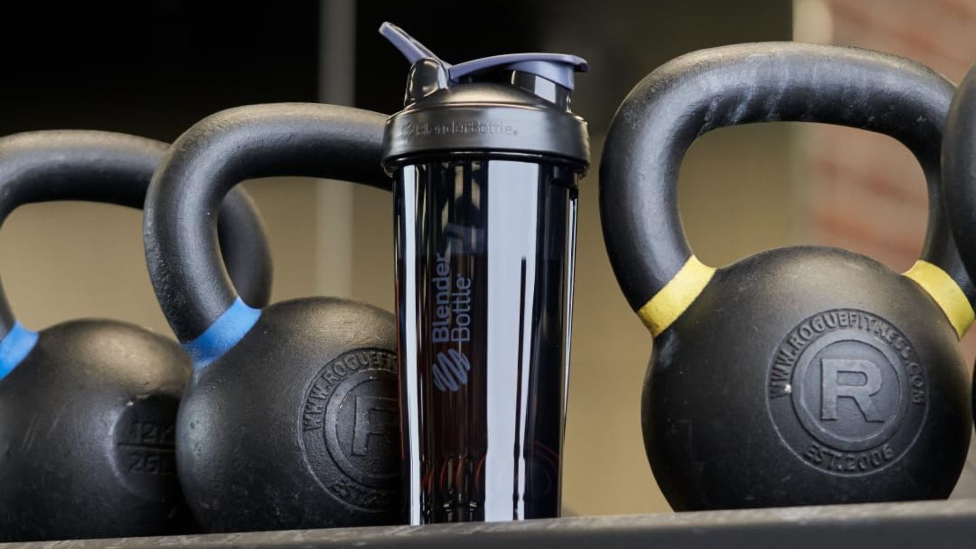 A BlenderBottle surrounded by kettlebells.