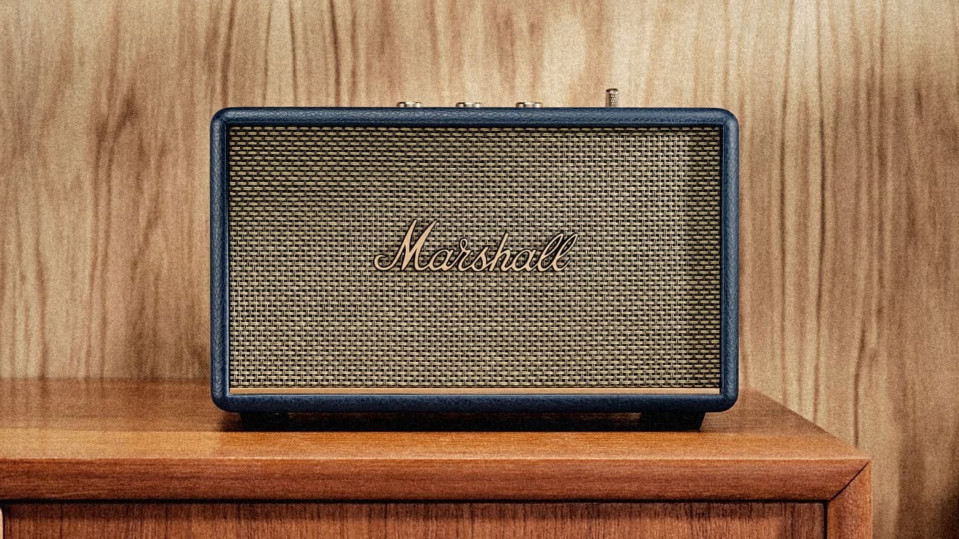 The Acton III speaker on a wooden dresser.
