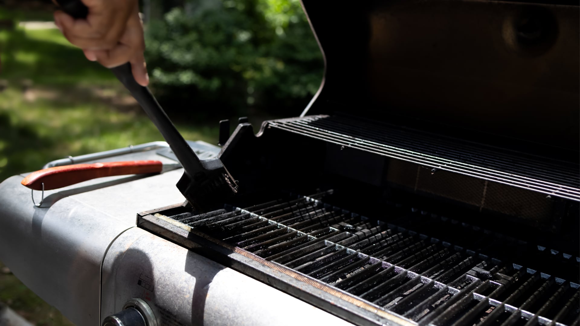 Person cleaning their BBQ grill