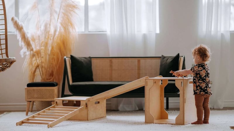 a child playing with a wooden structure in a living room
