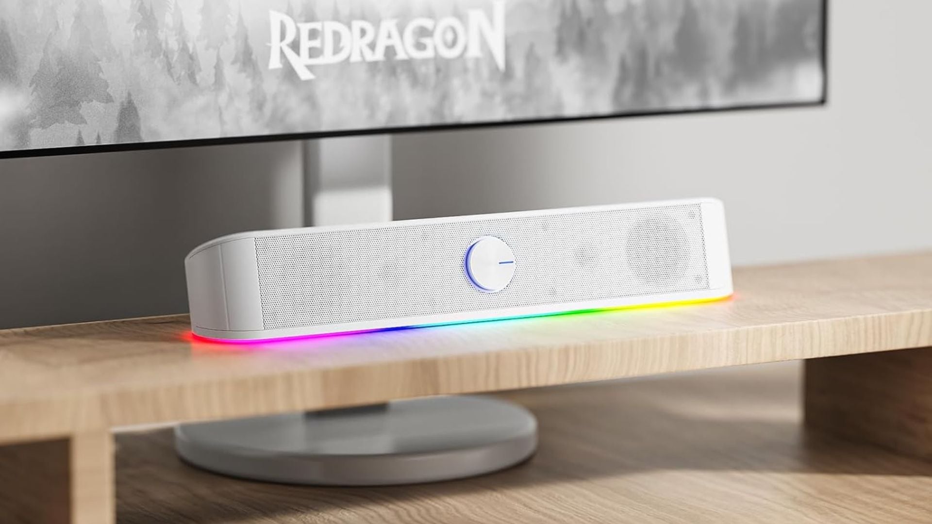 A Redragon soundbar in front of a computer monitor.
