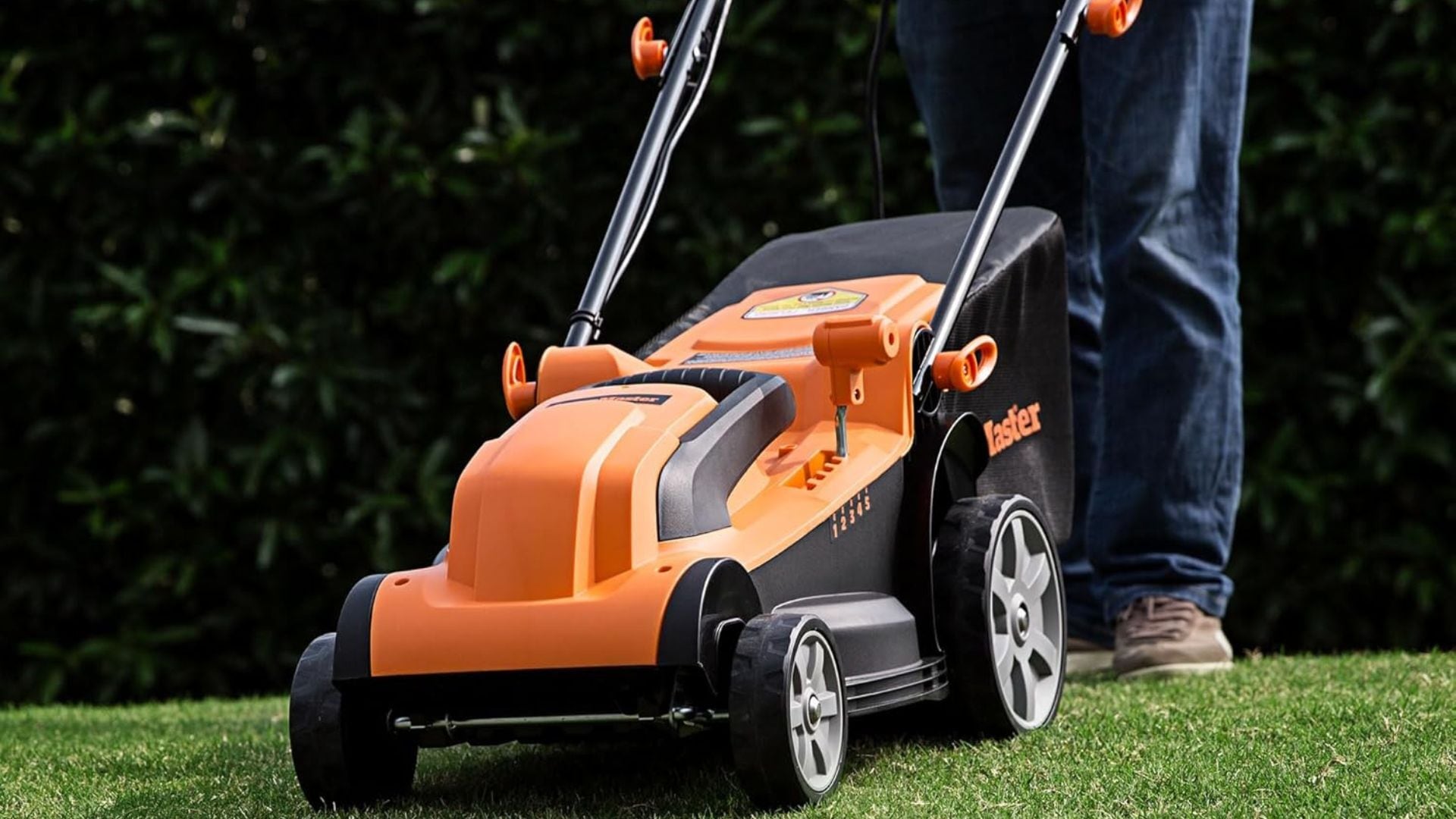 a person pushing a lawnmower on grass