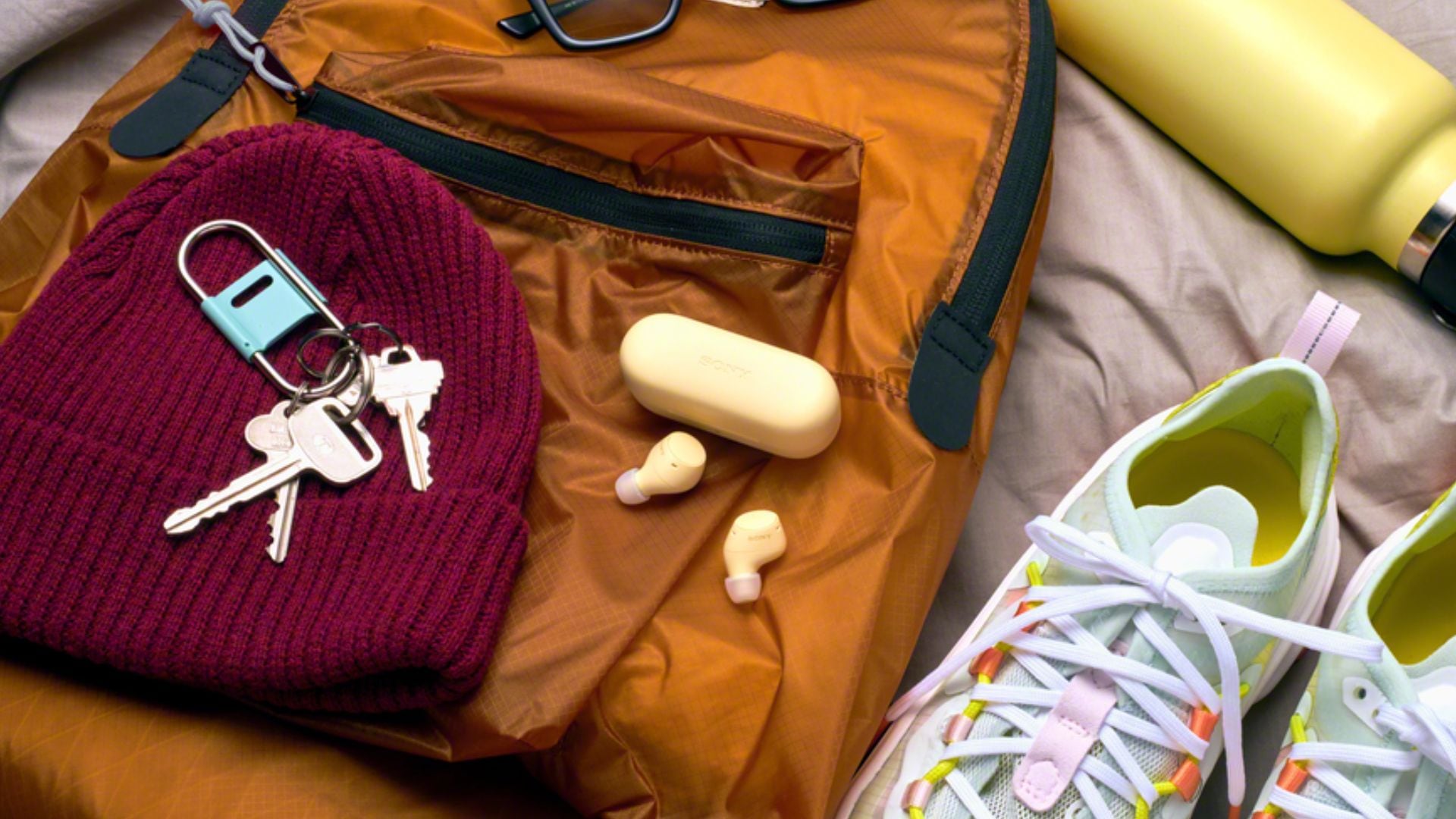 A pair of Sony earbuds surrounded by back-to-school essentials.