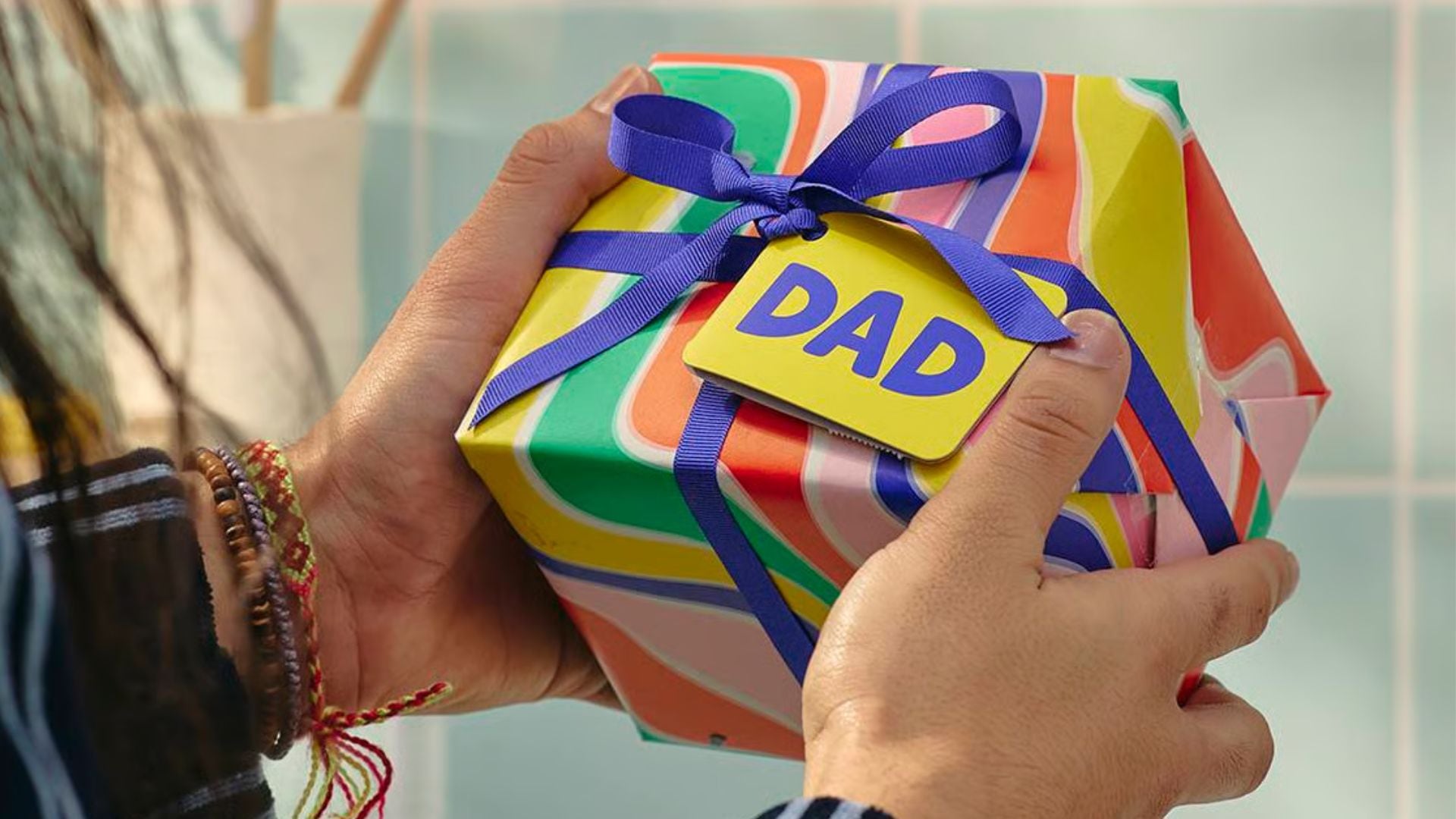 A person holding a colourful gift box from LUSH.