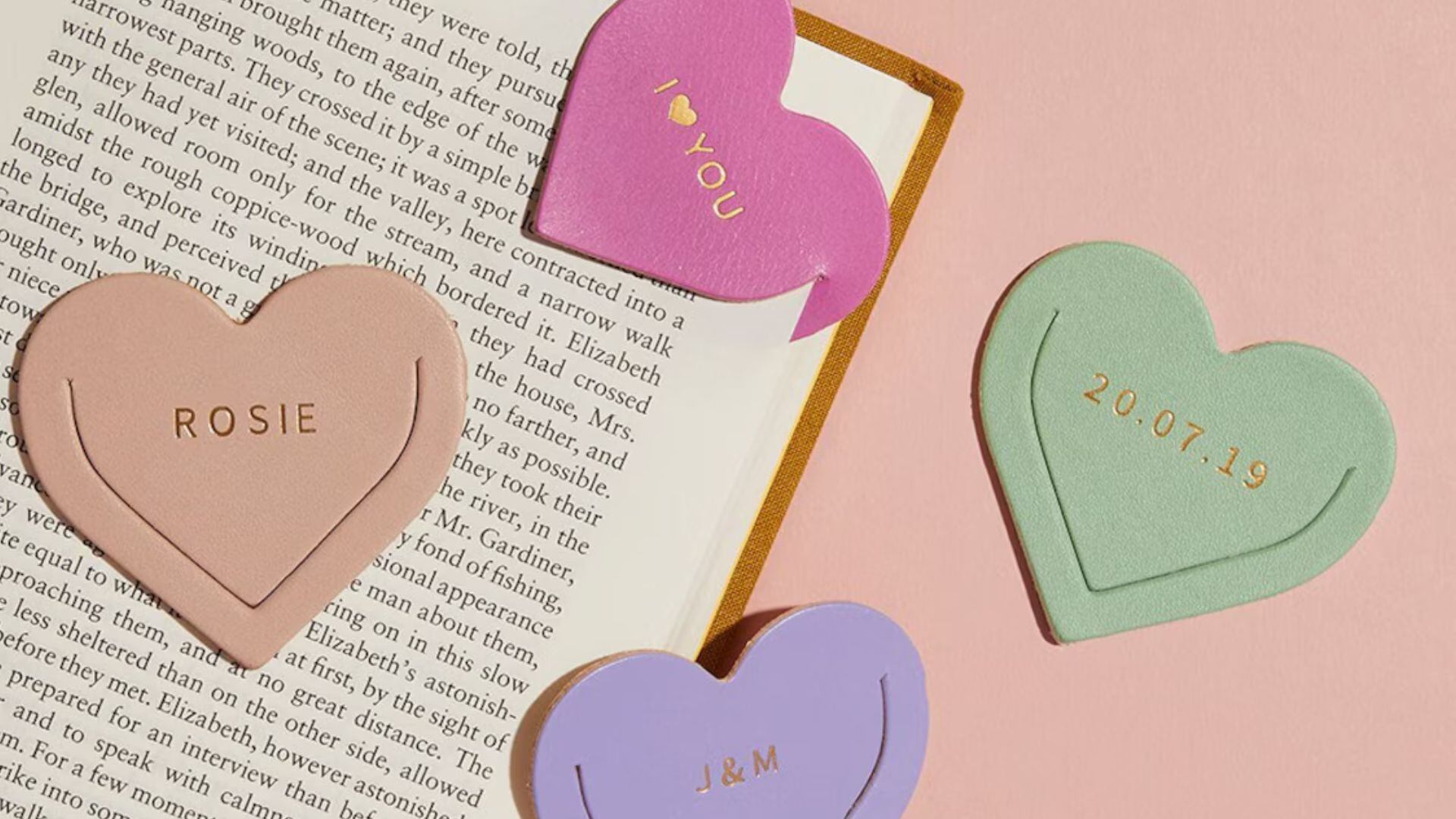 Four heart-shaped bookmarks on an open book.