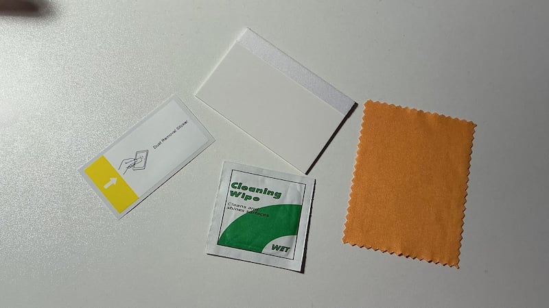 The dust sticker, squeegee, cleaning wipe, and cleaning cloth with a plain background