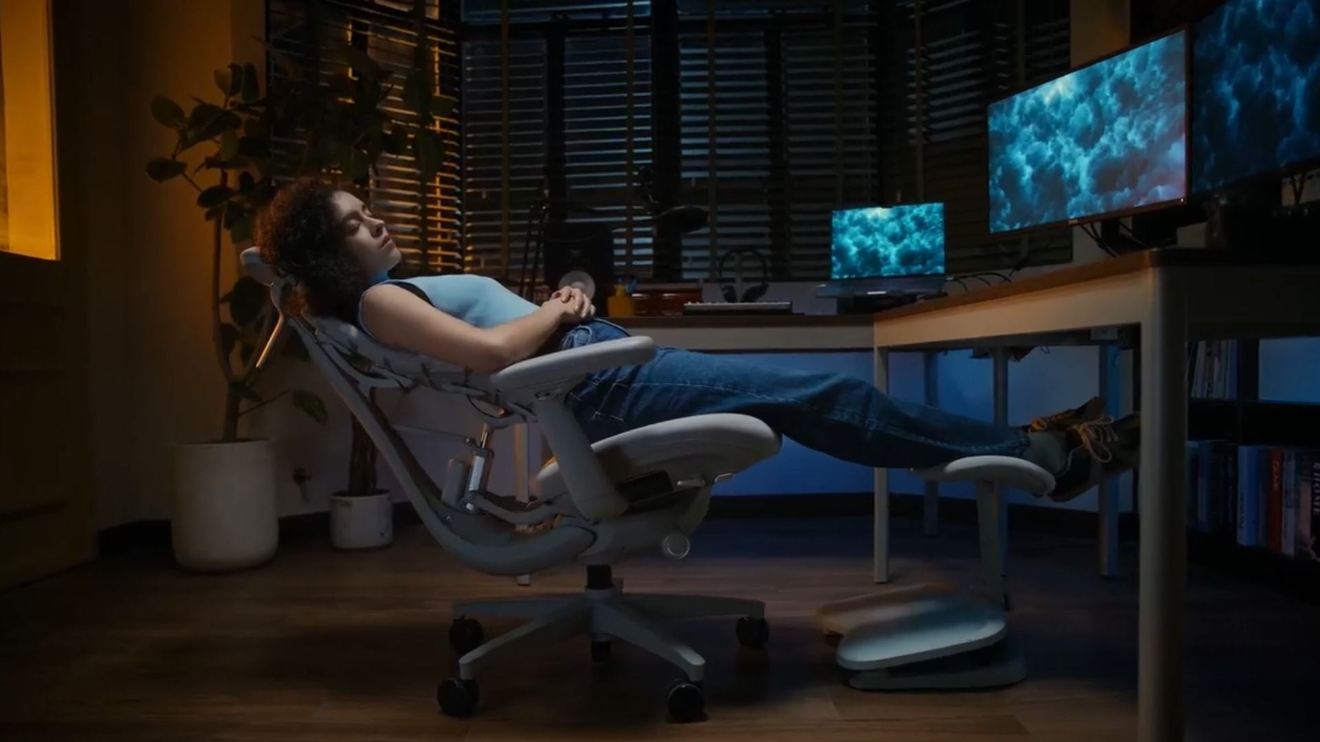 A person reclining in front of their desk on a LiberNovo Dynamic Ergonomic Office Chair.