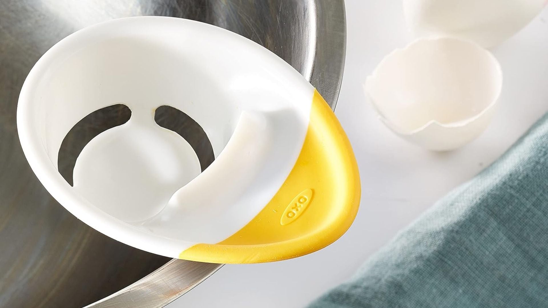 an egg separator on the edge of a bowl on a kitchen counter