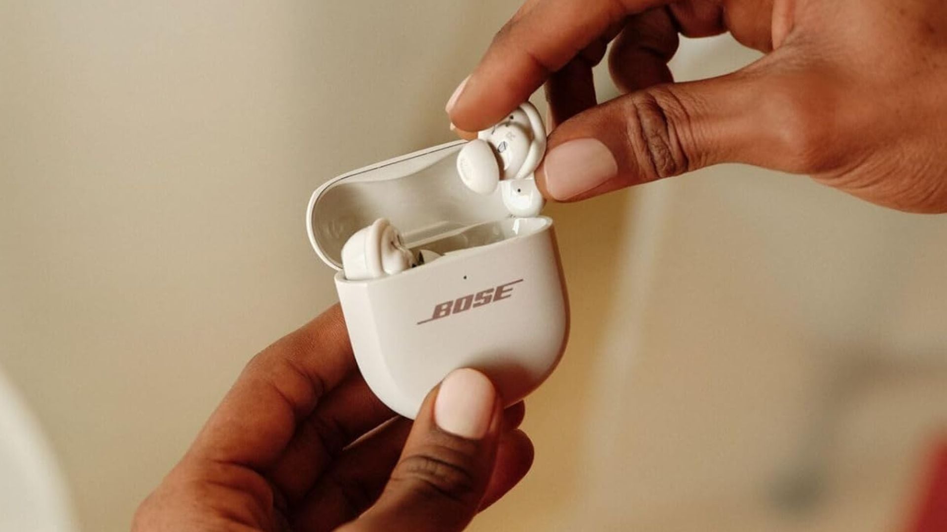A person taking Bose earbuds out of their case.