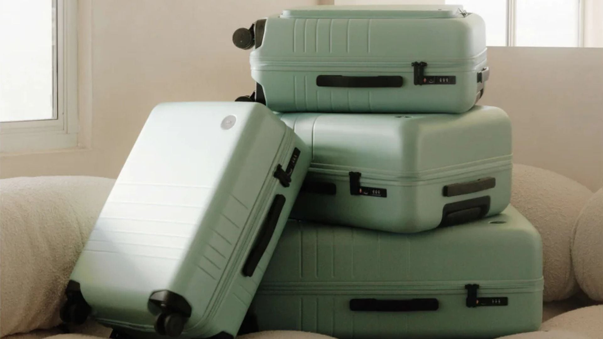 Four Monos suitcases on a couch.