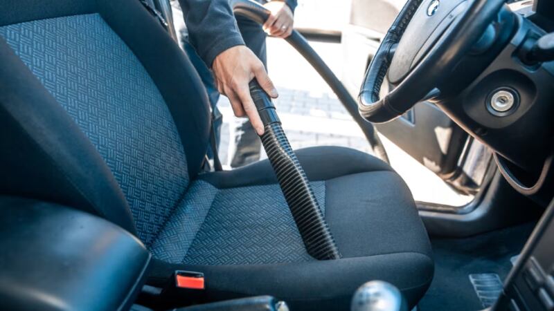 Person vacuuming the driver seat