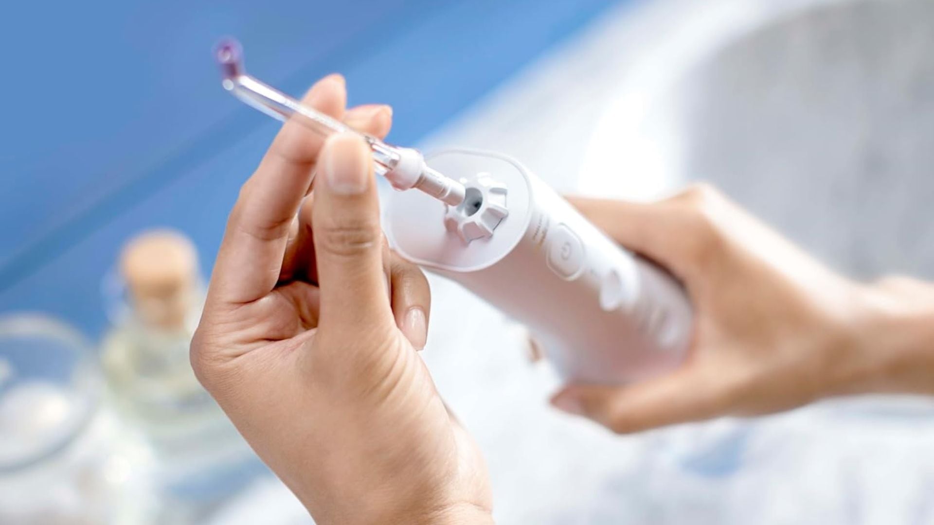 A person putting a tip on a water flosser.