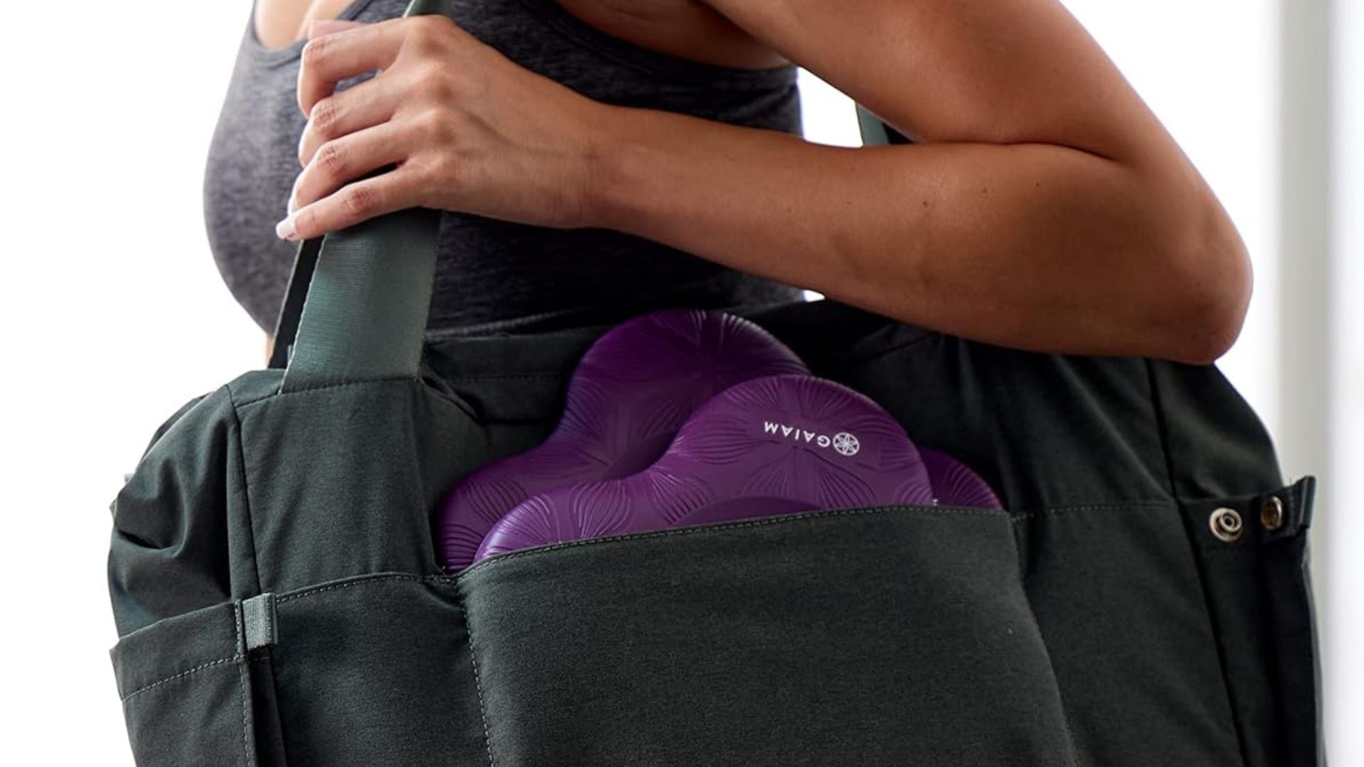 a person with a yoga bag on their shoulder and knee pads sticking out