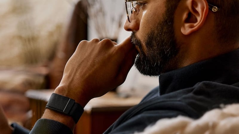 A person wearing a WHOOP Fitness Tracker while sitting in their living room.