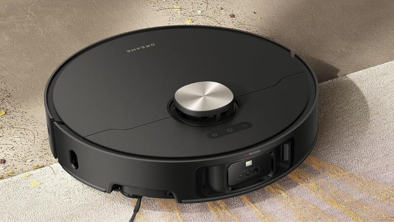 A robot vacuum is sucking up crumbs on a carpet.