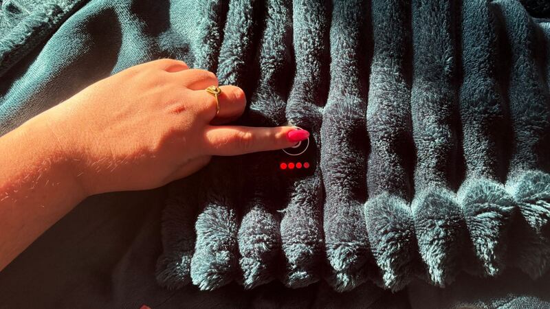 Bianca pressing the power button on the heated blanket