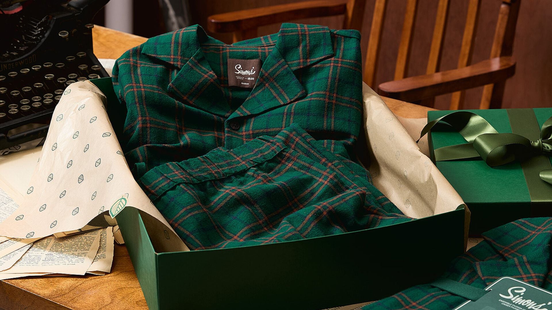 A flannel plaid pj set in a gift box on a table