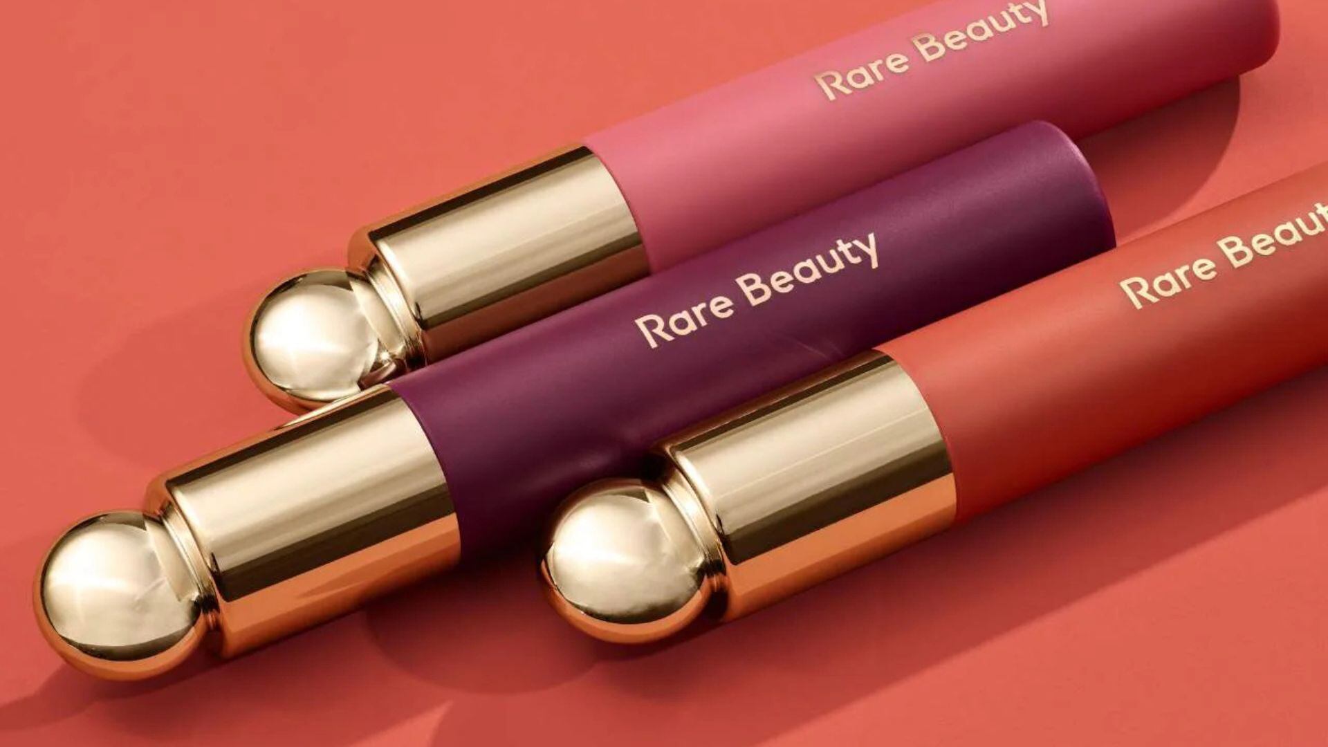 three lip stains with a plain background