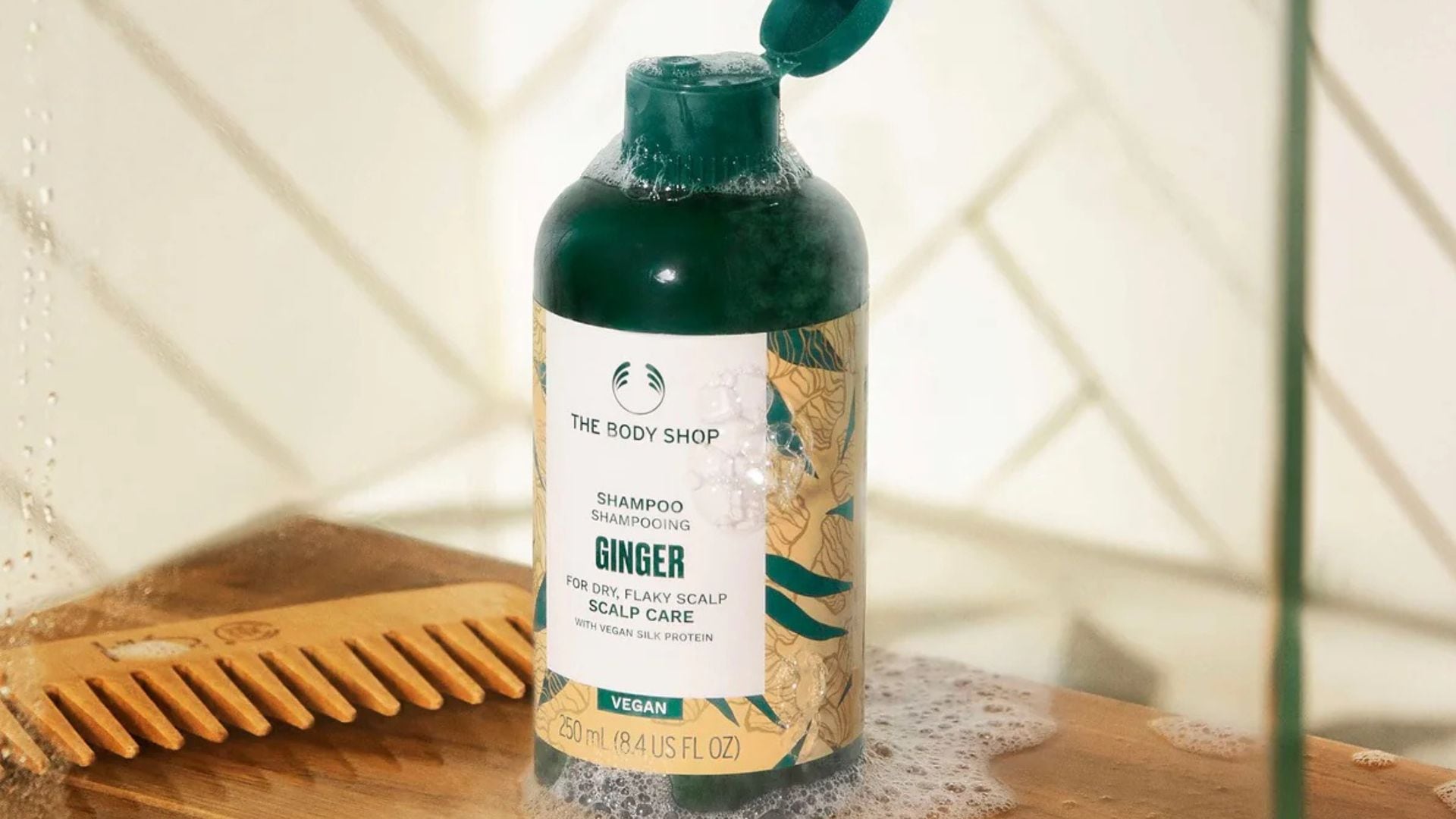 A bottle of The Body Shop anti-dandruff shampoo is on a counter.